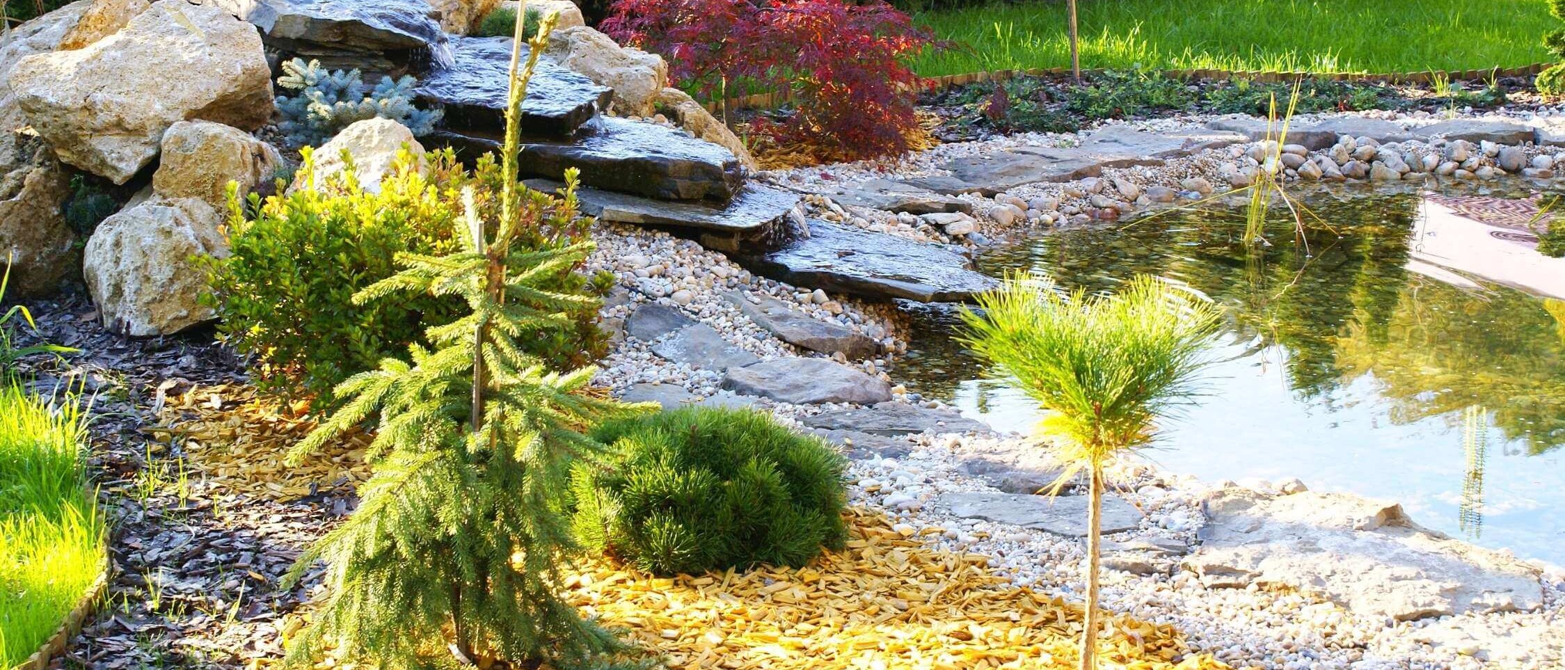 Stone garden fountain with flowing water as a decorative element in the exterior - realization of water elements.