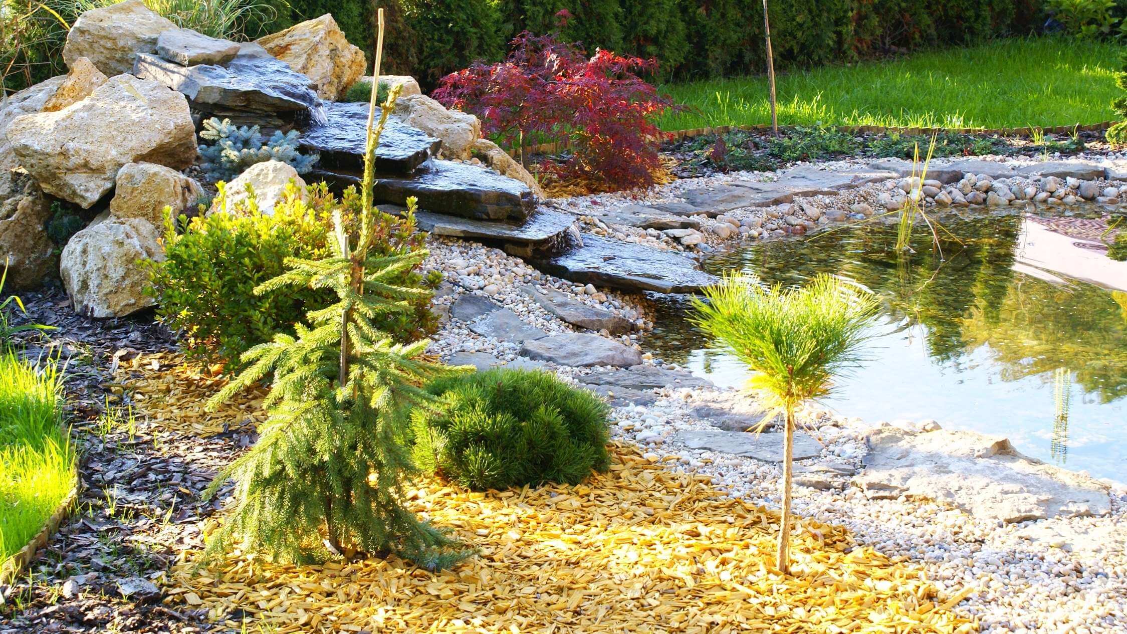 Stone garden fountain with flowing water as a decorative element in the exterior - realization of water elements.